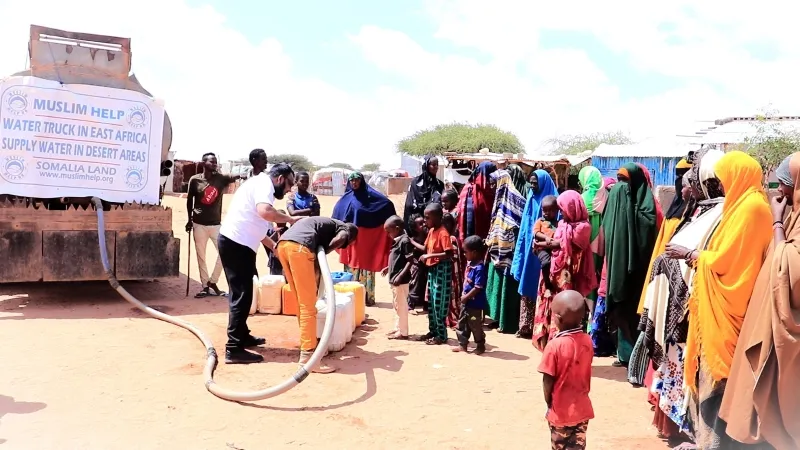 Families queuing at a water truck for clean water in Somalia